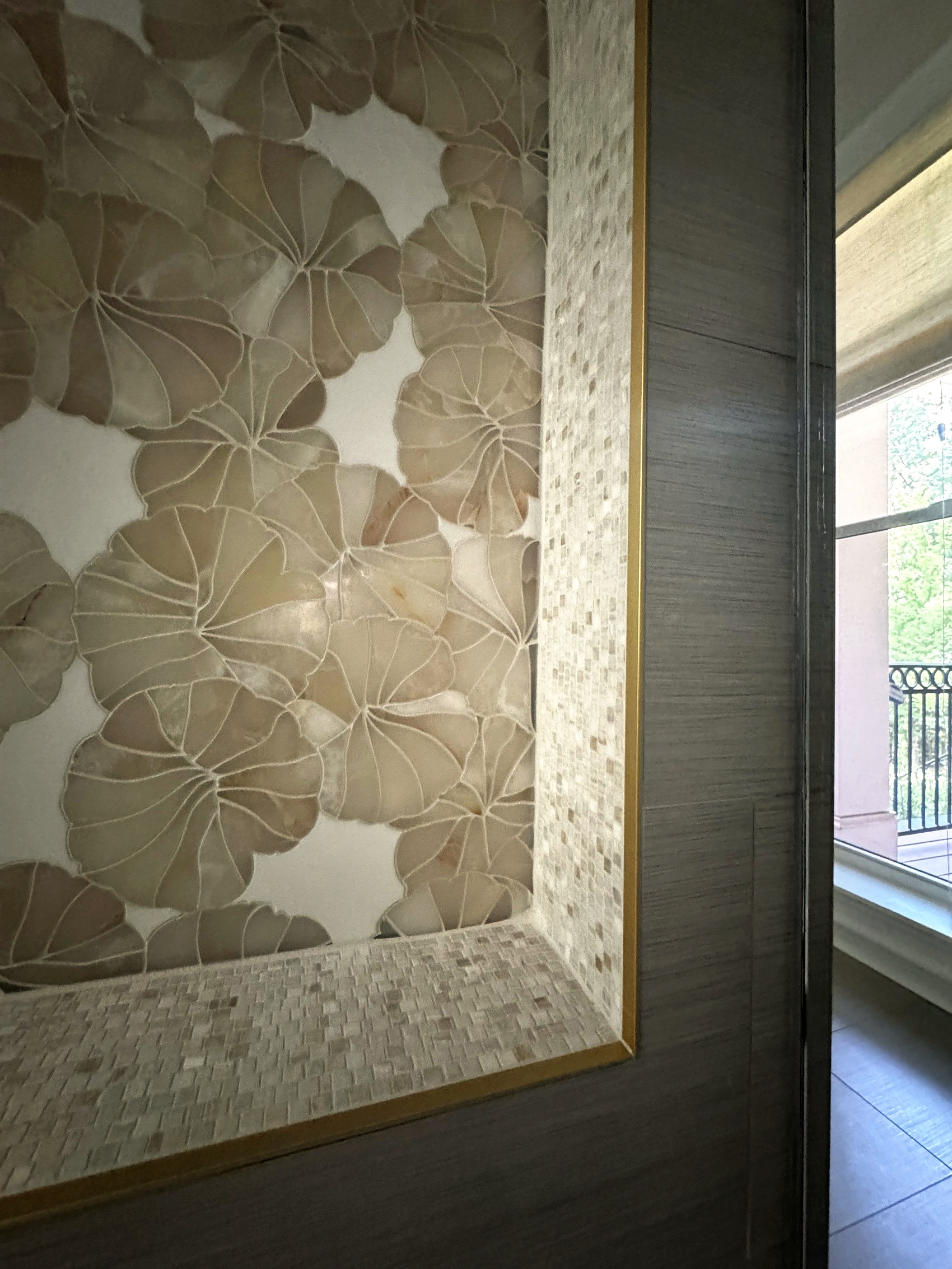 Close-up of mosaic floral tile in the arched shower niche.