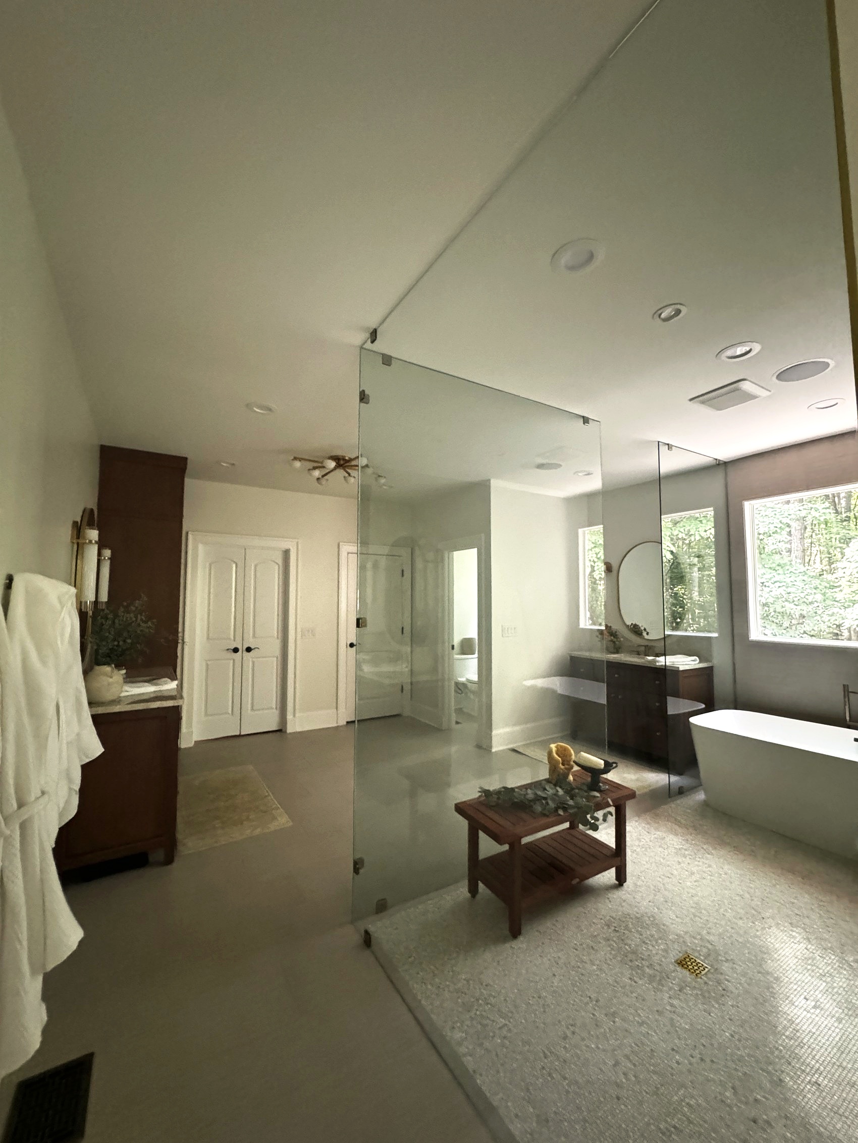 Wide view of primary bathroom with glass shower enclosure and freestanding tub.