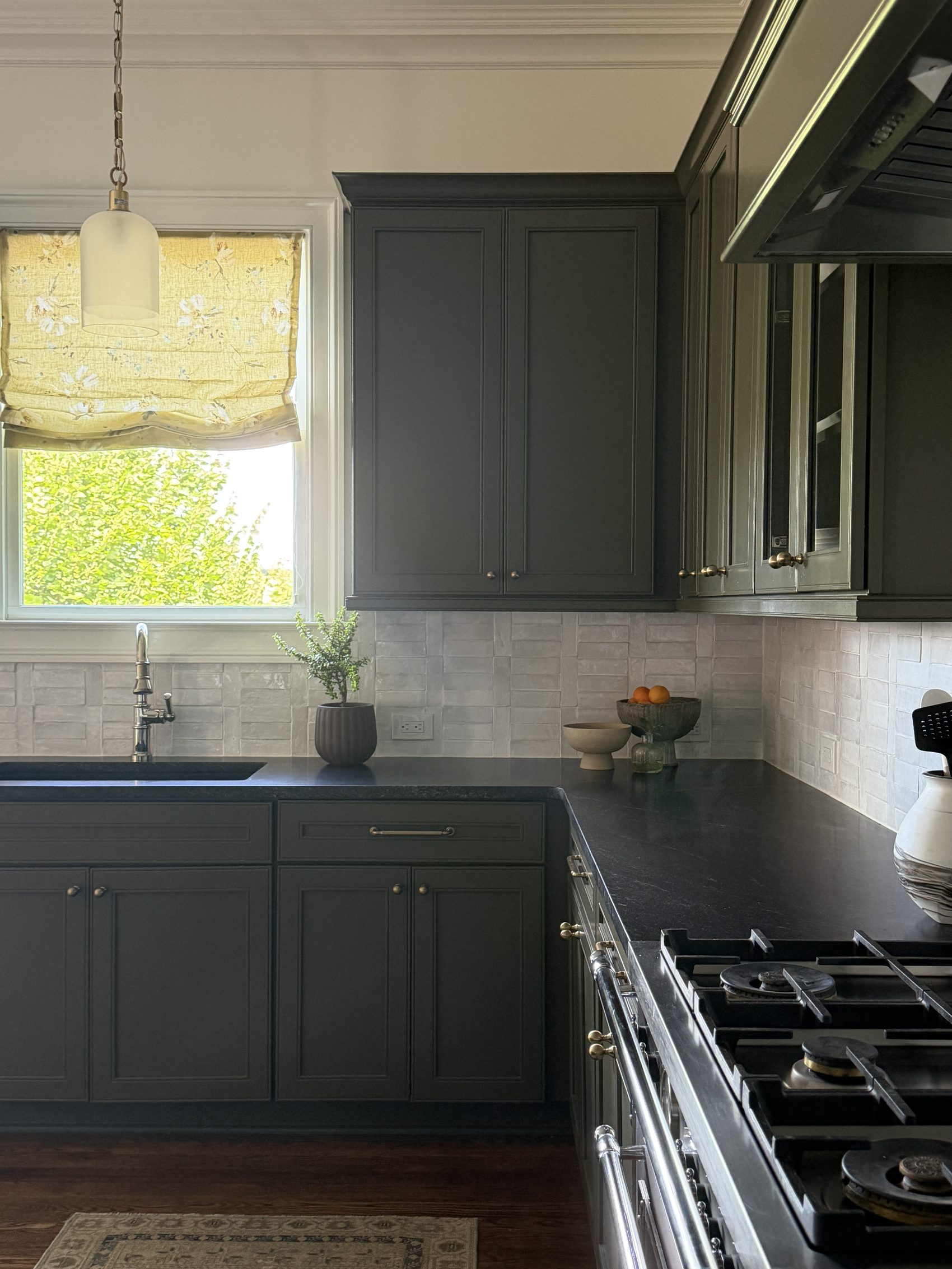 Wide kitchen view toward the window and sink, with pendant light and citrus bowl on the counter.