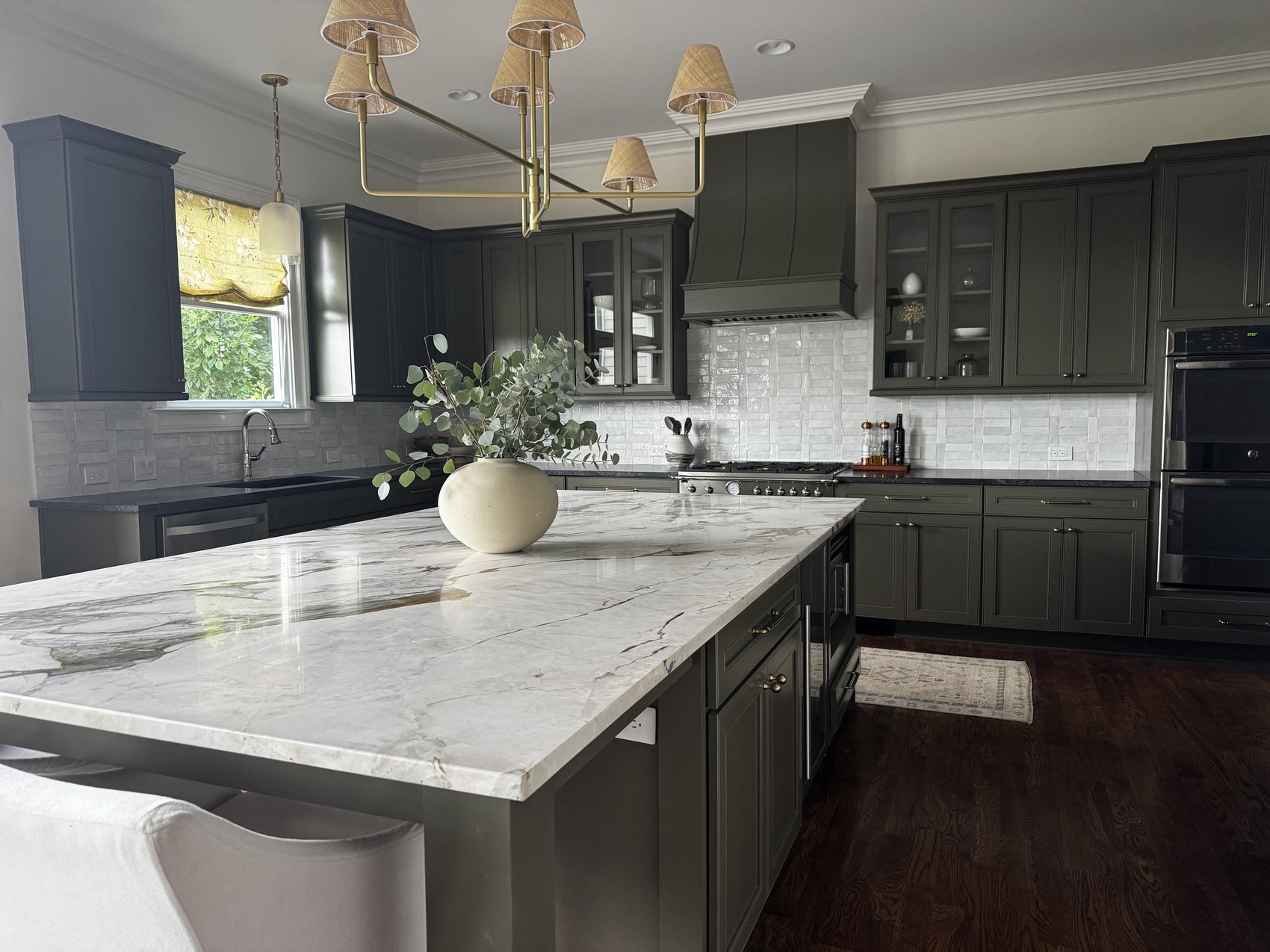 A renovated kitchen with white cabinetry and a walnut island.
