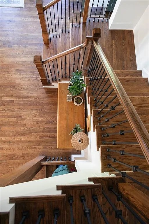 View down an oak staircase with wrought iron balusters.