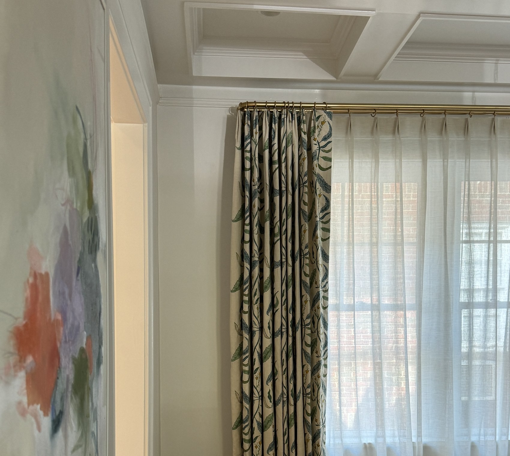 Tall botanical curtain detail near a bright window.