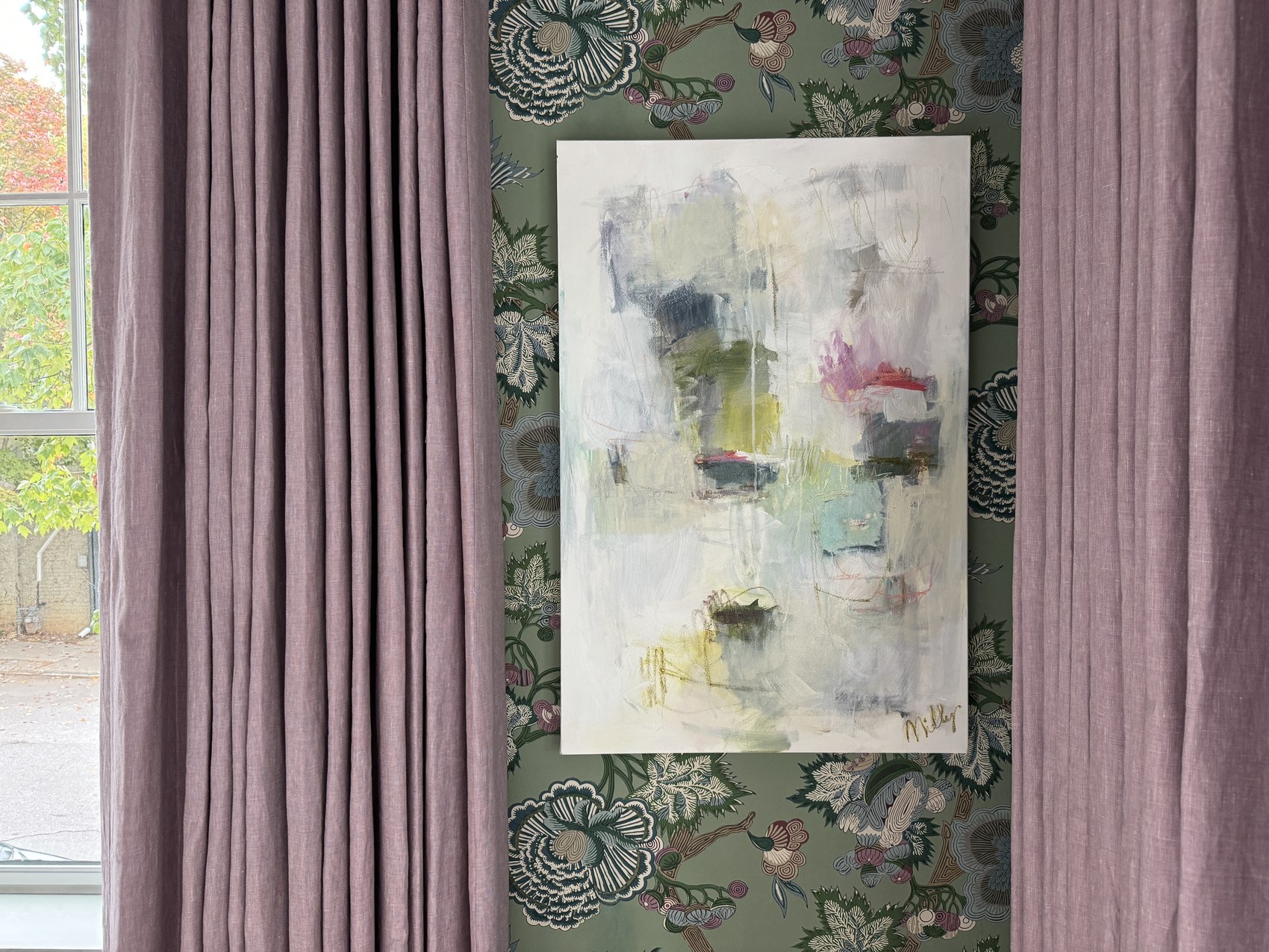 Mauve linen curtains against botanical green wallpaper with an original abstract painting.