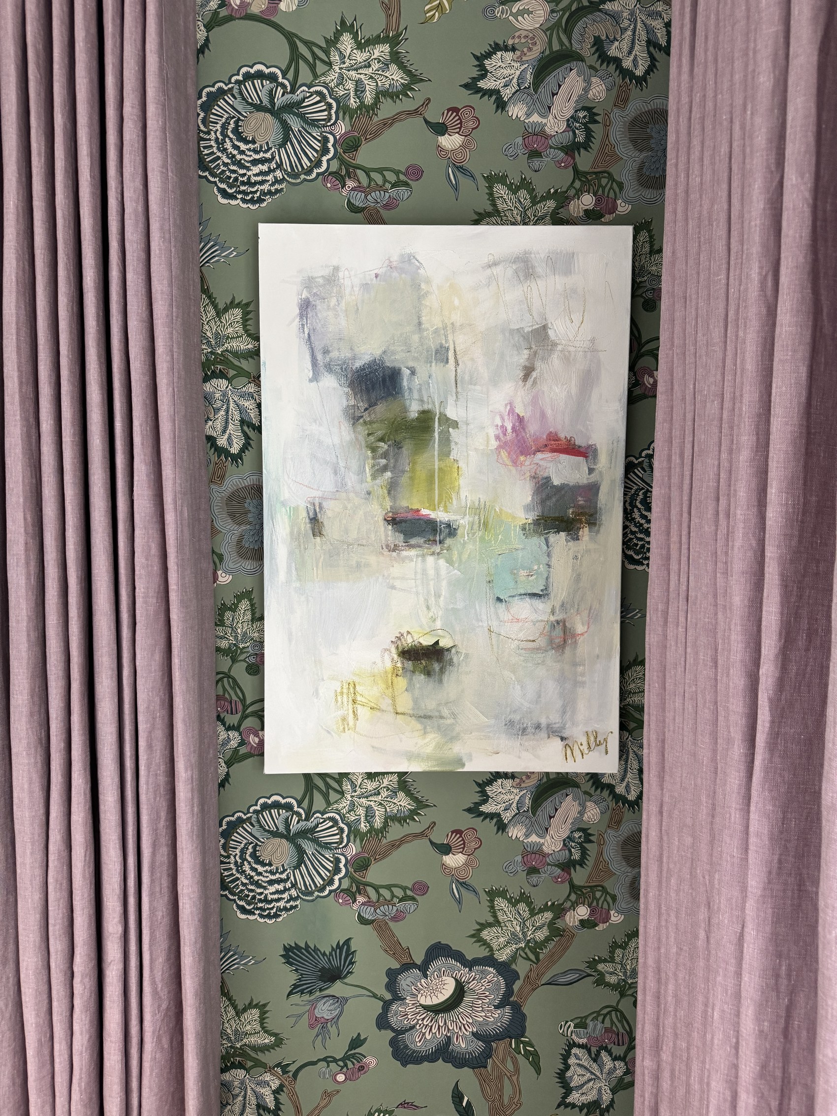 Close view of mauve curtains, green wallpaper, and original abstract painting.