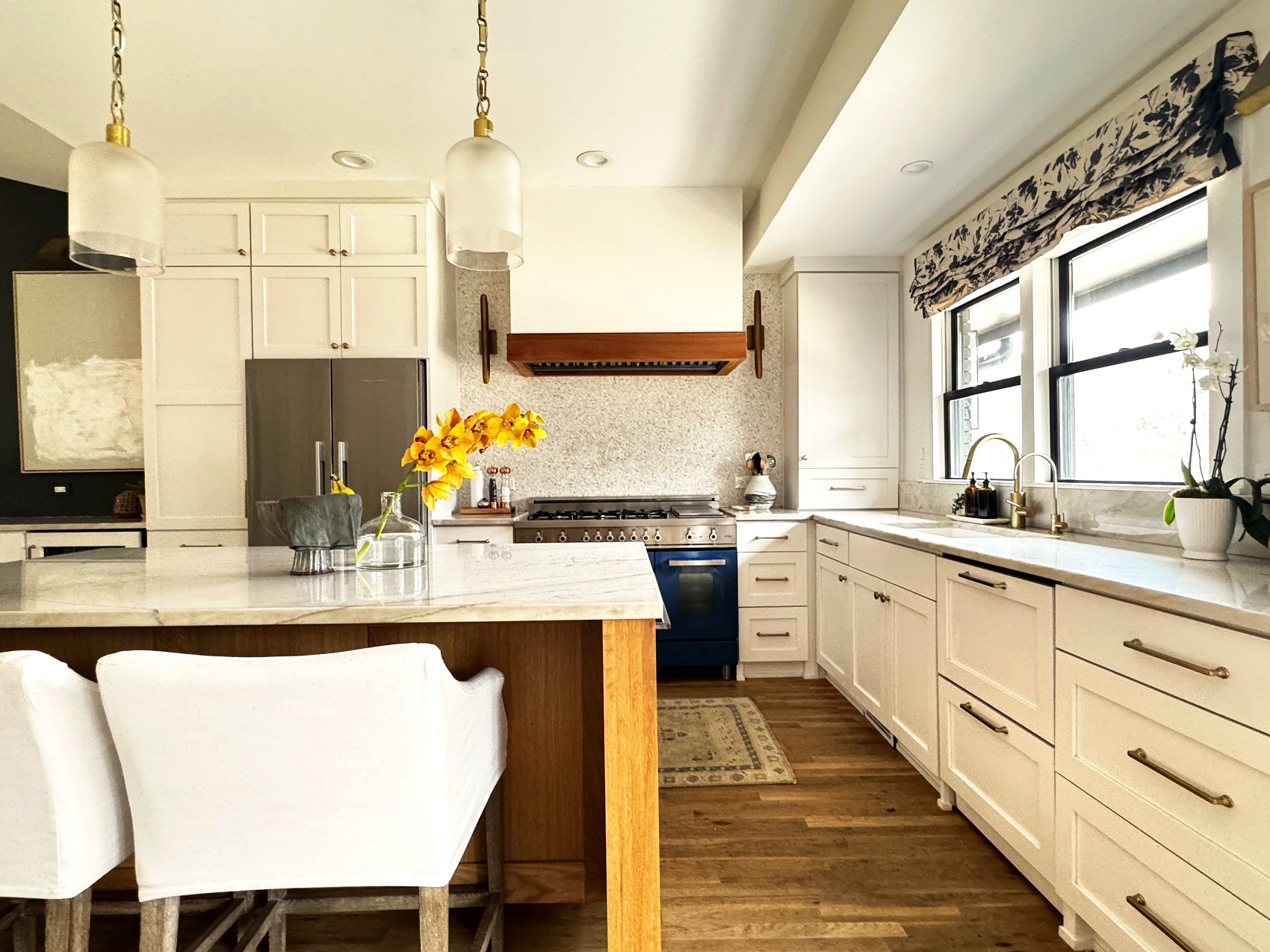 Kitchen with pendant lighting, a floral roman shade, and navy range.